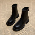Women's black ankle boot with round toe, thick flat heel, and rear zipper on a rubber sole.
