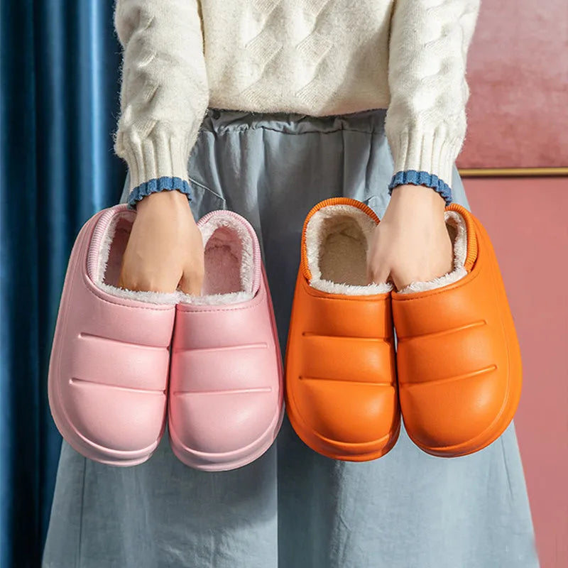 Green waterproof EVA garden slippers with plush lining and a non-slip sole, shown on a wooden deck.