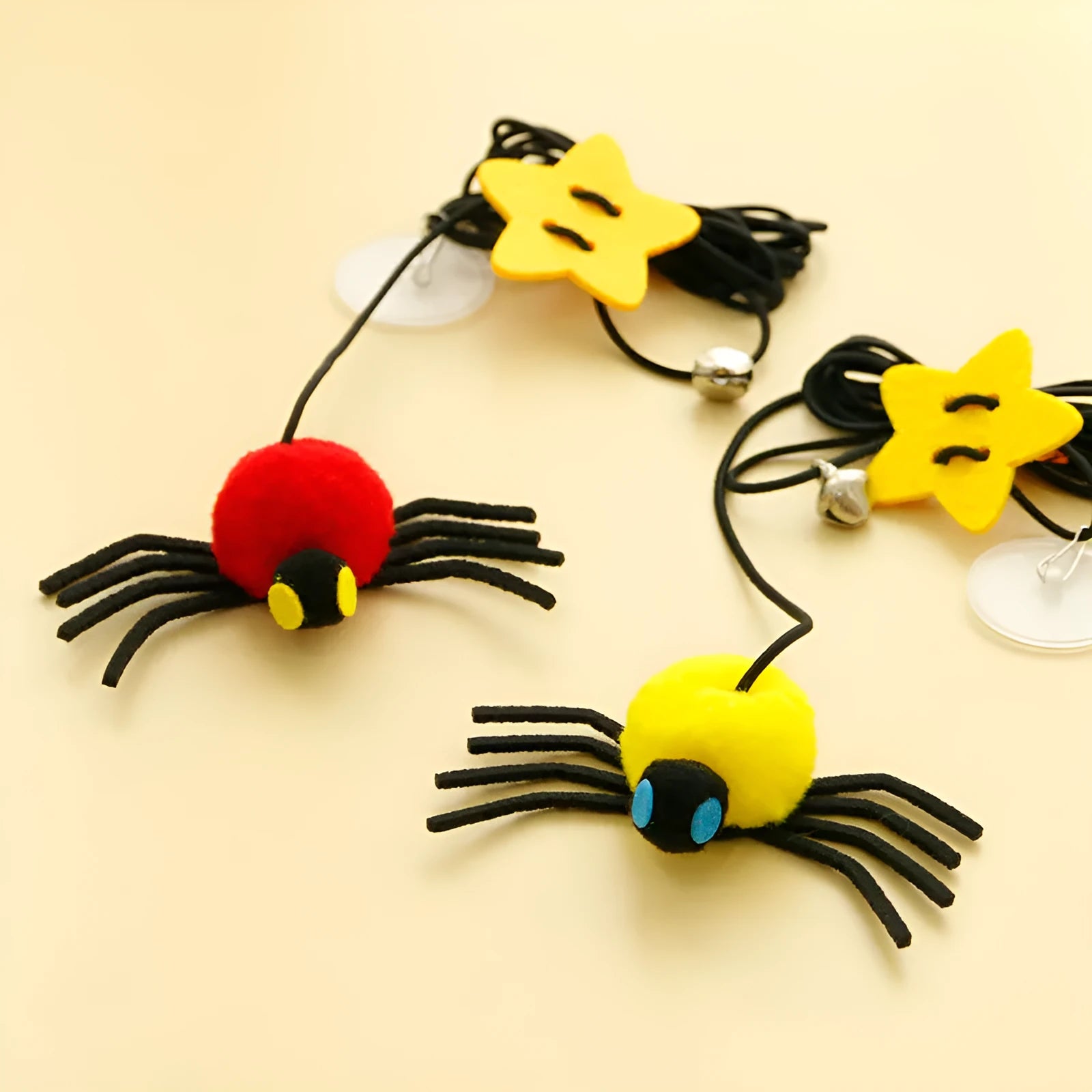 Red and yellow cat hanging door toy with elastic rope, feather, bell, and spider decoration.